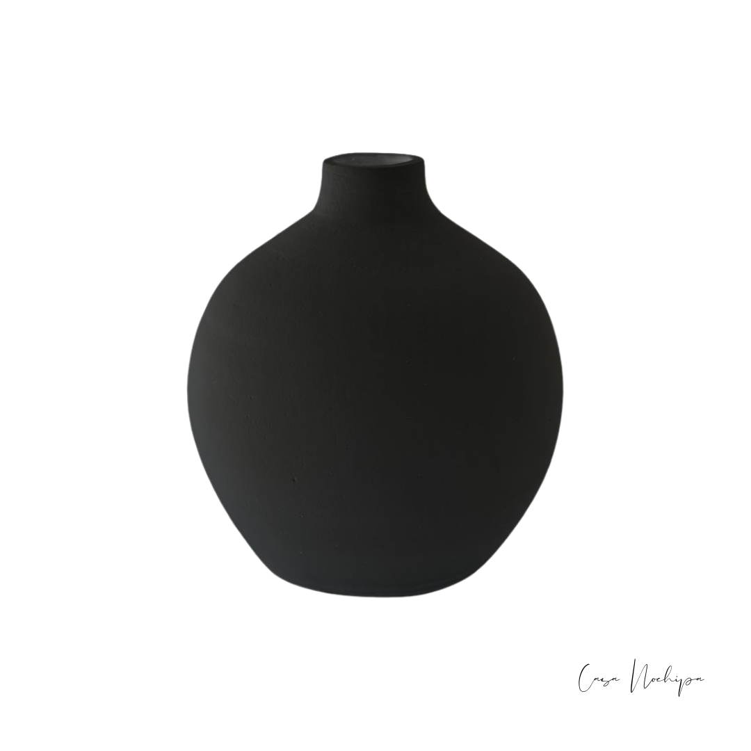 Jarrón de barro negro artesanal con acabado mate, ideal para decoración de interiores.
