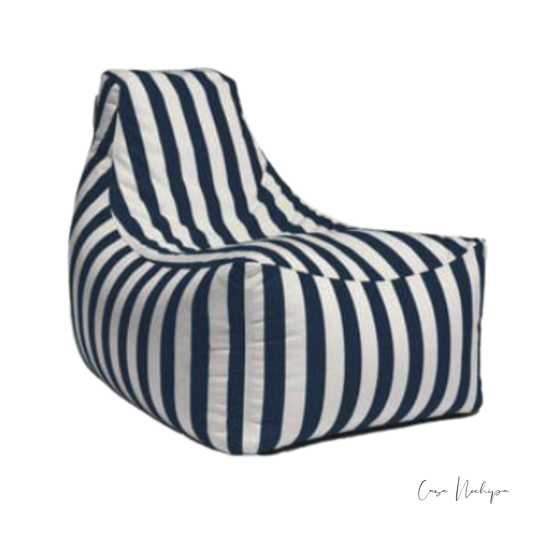 Sillón bajo tapizado en tela Sunbrella con rayas náuticas en azul y blanco.