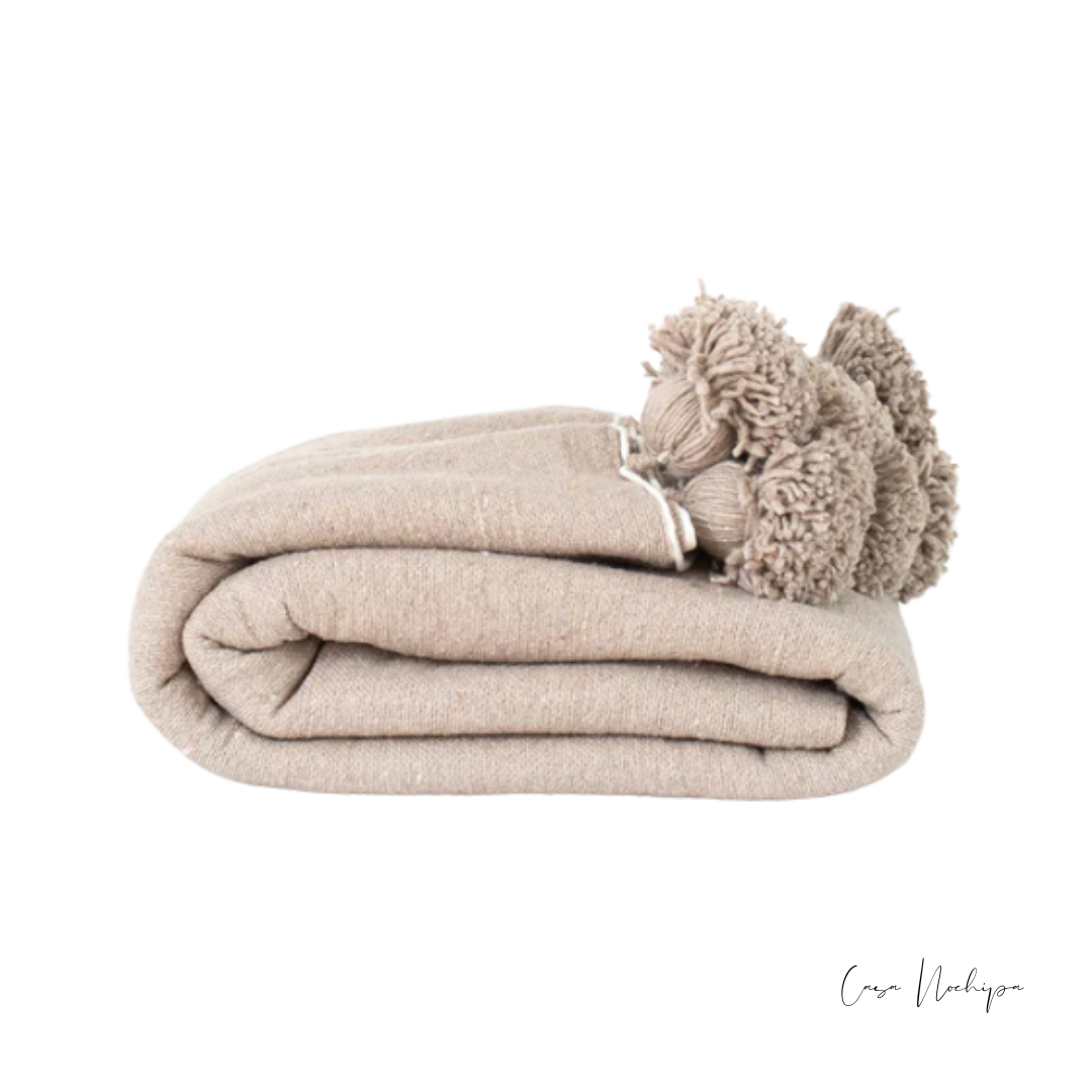 Frazada artesanal beige natural con pompones tejidos a mano en telar de pedal