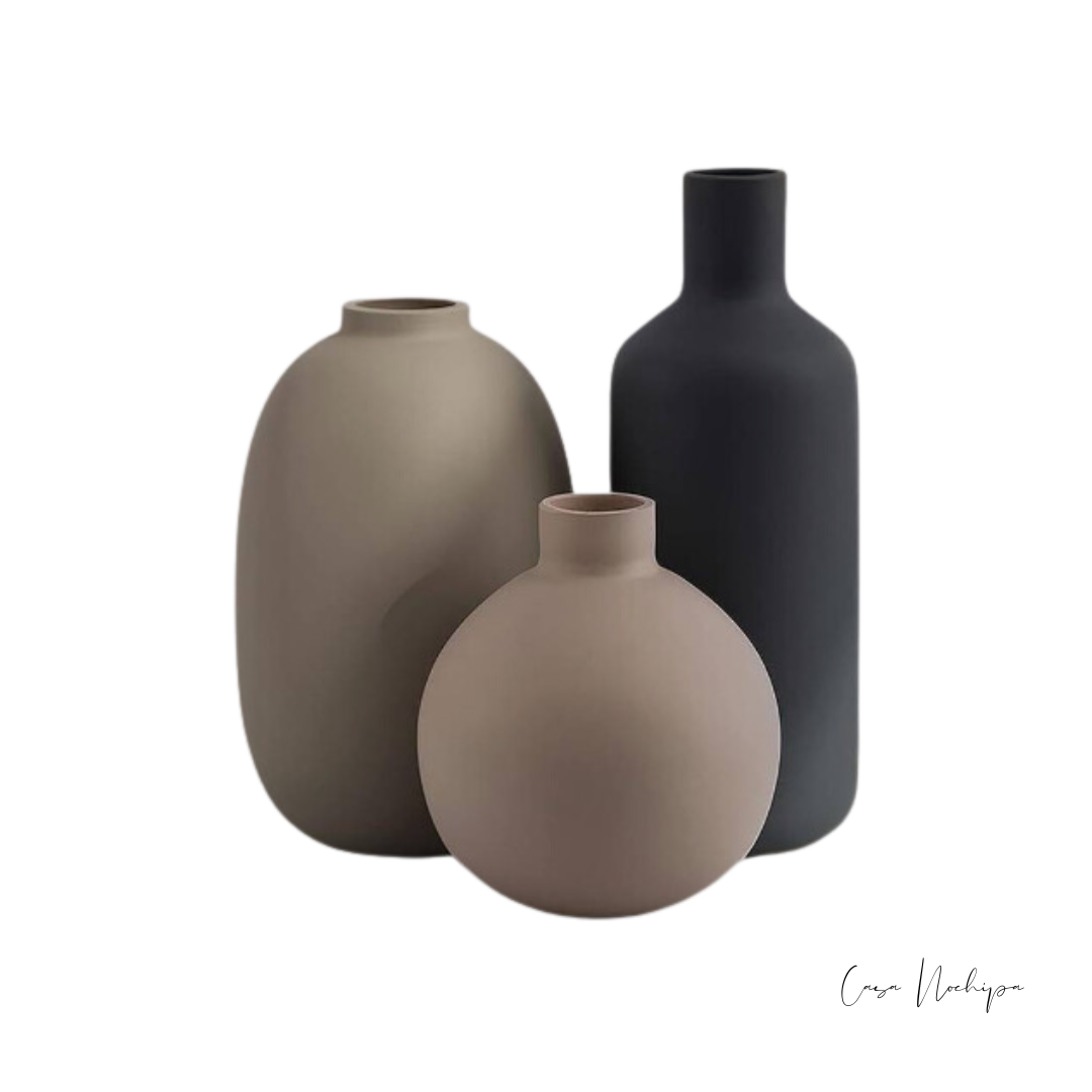 Juego de tres tarros de barro en diferentes tamaños con acabado mate, ideales para decoración interior.