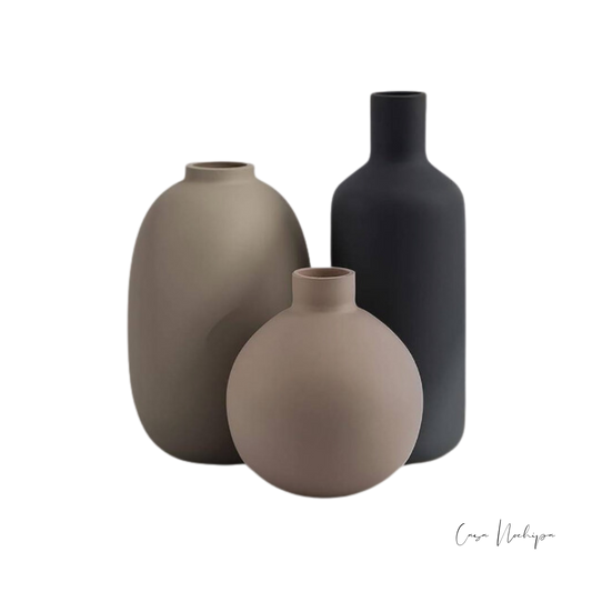 Juego de tres tarros de barro en diferentes tamaños con acabado mate, ideales para decoración interior.