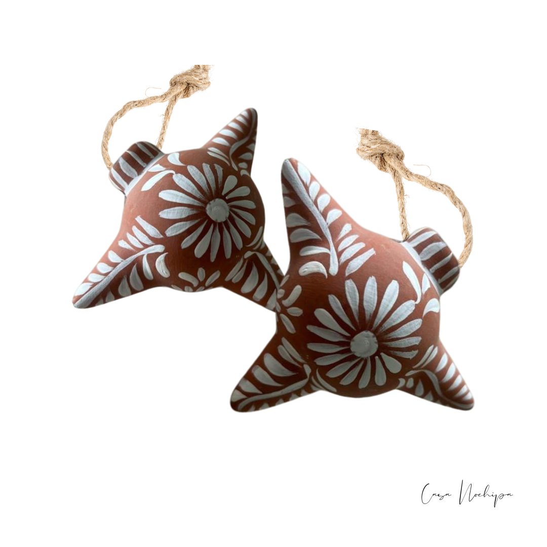 Esfera estrella de barro terracota pintada a mano con flores blancas y cordón de yute.