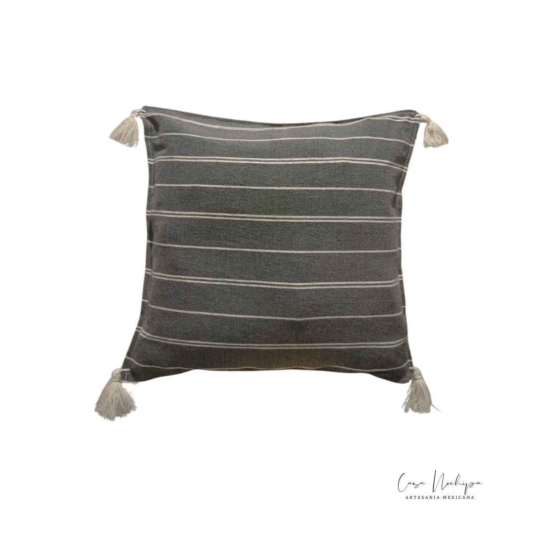 Cojín artesanal de algodón con diseño de rayas minimalistas y flecos, elaborado en Oaxaca.