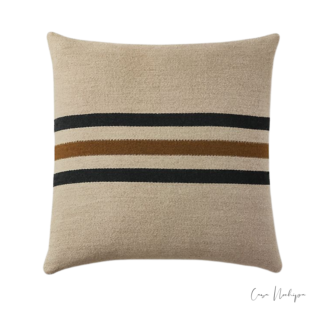 Cojín decorativo de lana con franjas negras y café sobre fondo beige, 50x50 cm