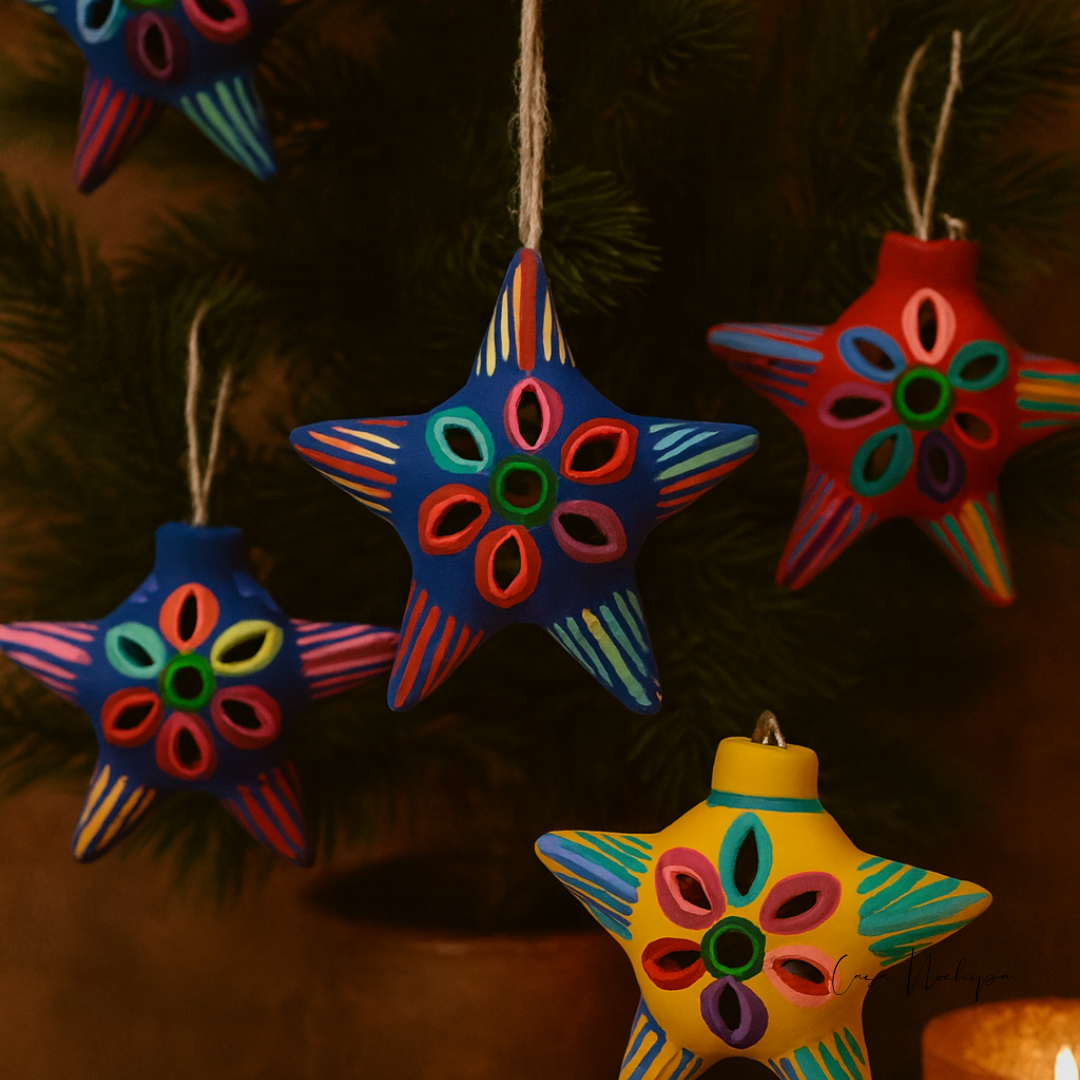 Estrella navideña de barro pintada a mano en azul con diseño floral multicolor.