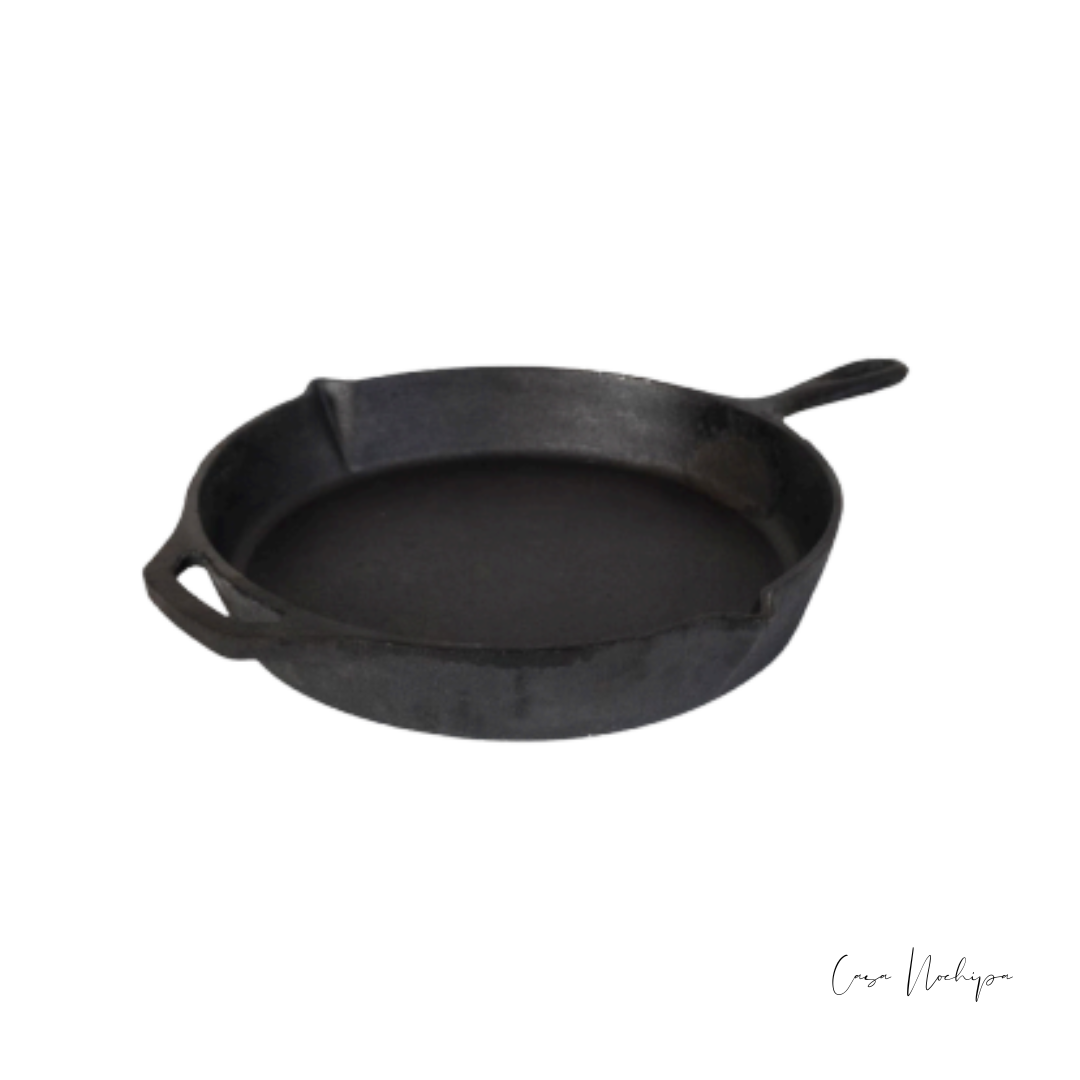 Sartén de hierro fundido con base de madera, ideal para cocinar carnes, verduras y recetas tradicionales con distribución uniforme del calor.