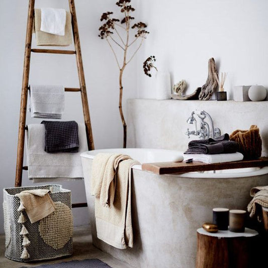 Una sala de estar moderna con un tapete artesanal de Casa Nochipa, cojines de lana natural y una mesa de centro decorada con cerámica de barro negro.