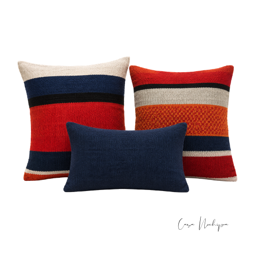 Set de tres cojines artesanales de lana en rojo, naranja y azul con diseño de franjas tejido en telar de pedal