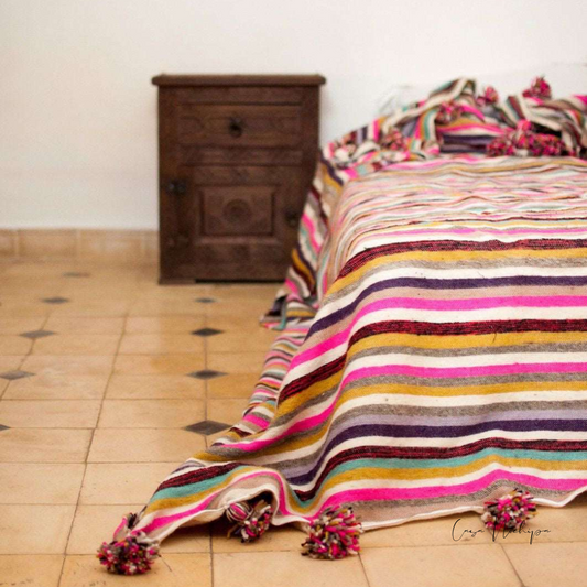 Frazada artesanal mexicana con rayas multicolor y borlas, tejida a mano en lana o algodón