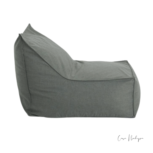 Sillón bajo minimalista tapizado en tela Sunbrella gris.