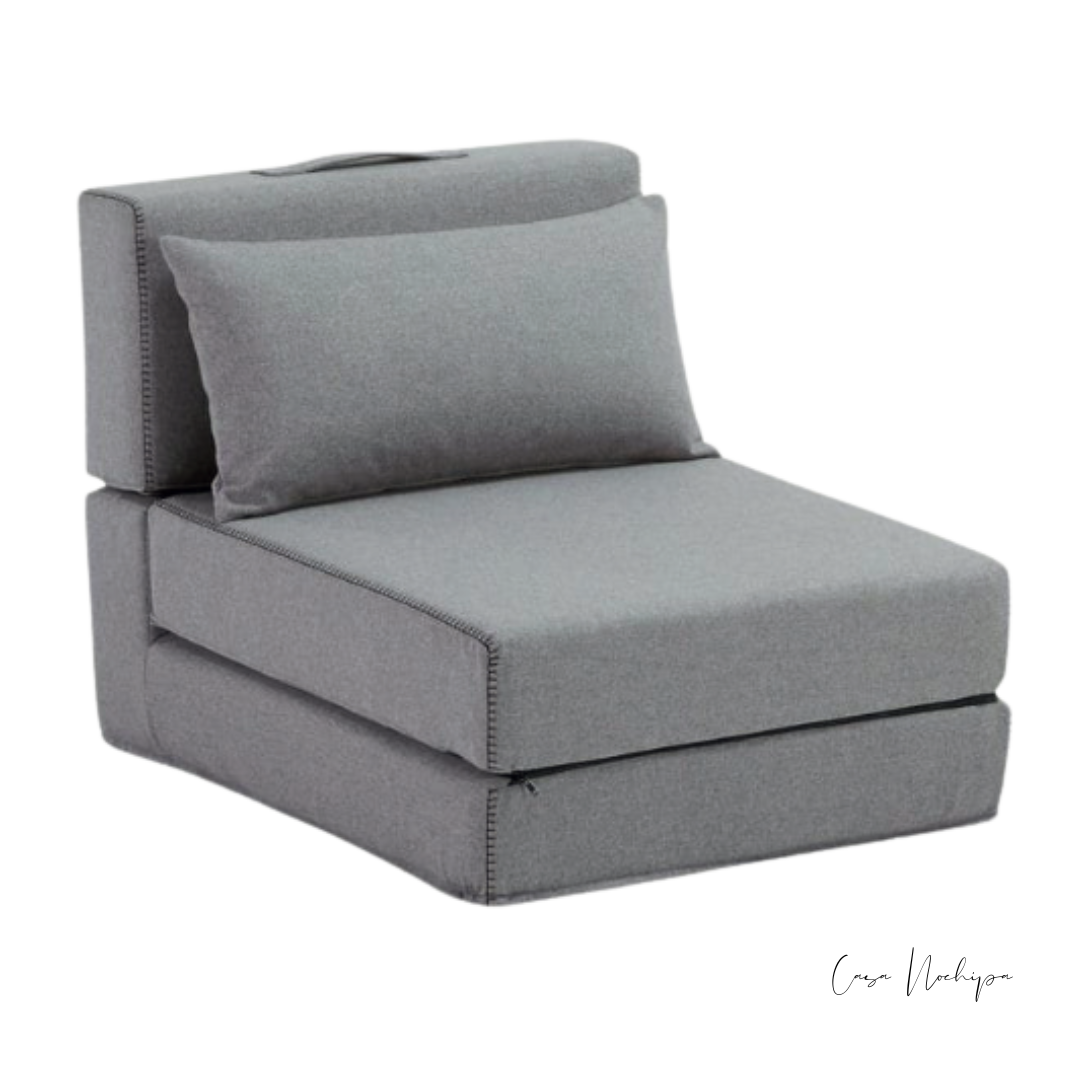 Sillón plegable tapizado en tela Sunbrella gris, convertible en futón.