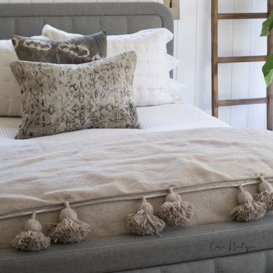 Frazada artesanal beige natural con pompones tejidos a mano en telar de pedal