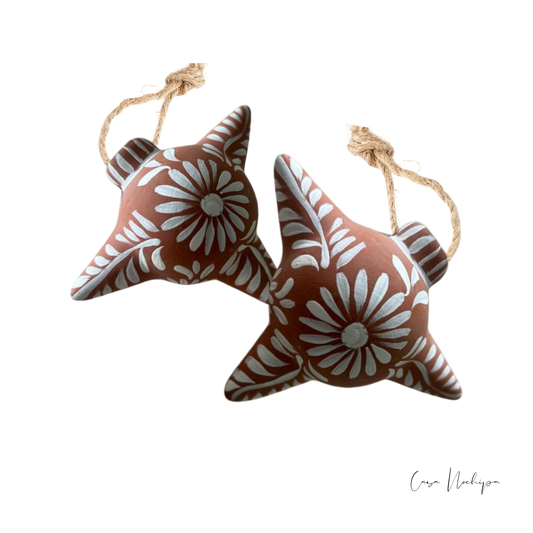Esfera estrella de barro terracota pintada a mano con flores blancas y cordón de yute.