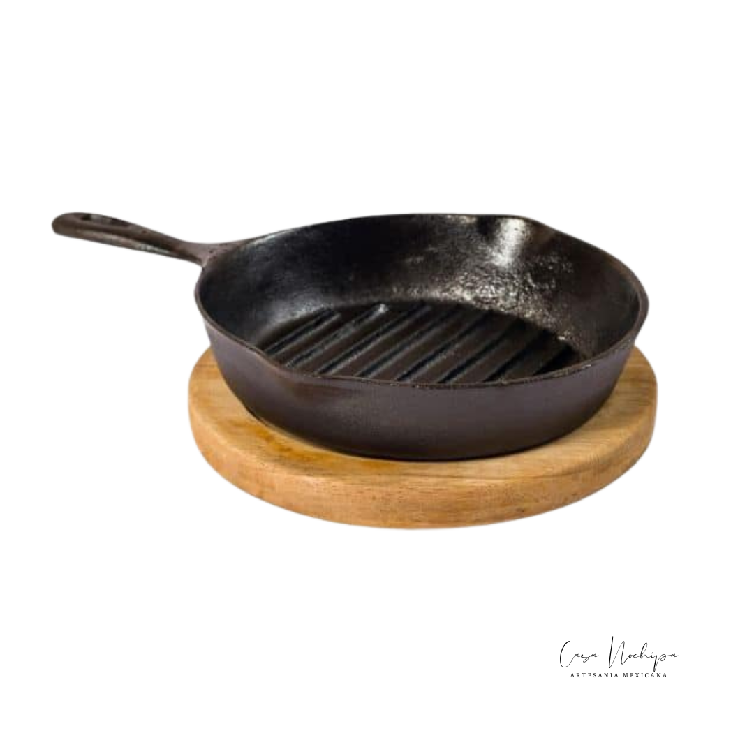 Sartén grill de hierro fundido con base de madera de parota, ideal para asar y servir.