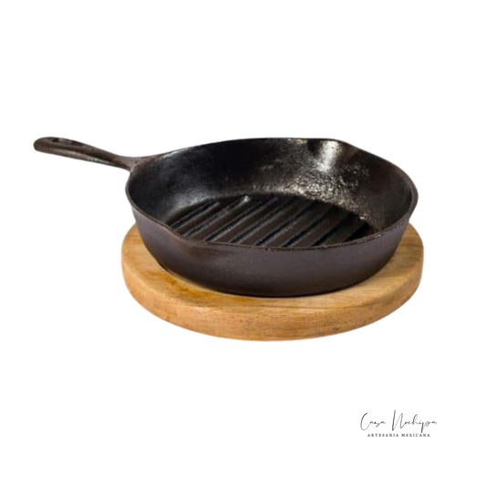 Sartén grill de hierro fundido con base de madera de parota, ideal para asar y servir.