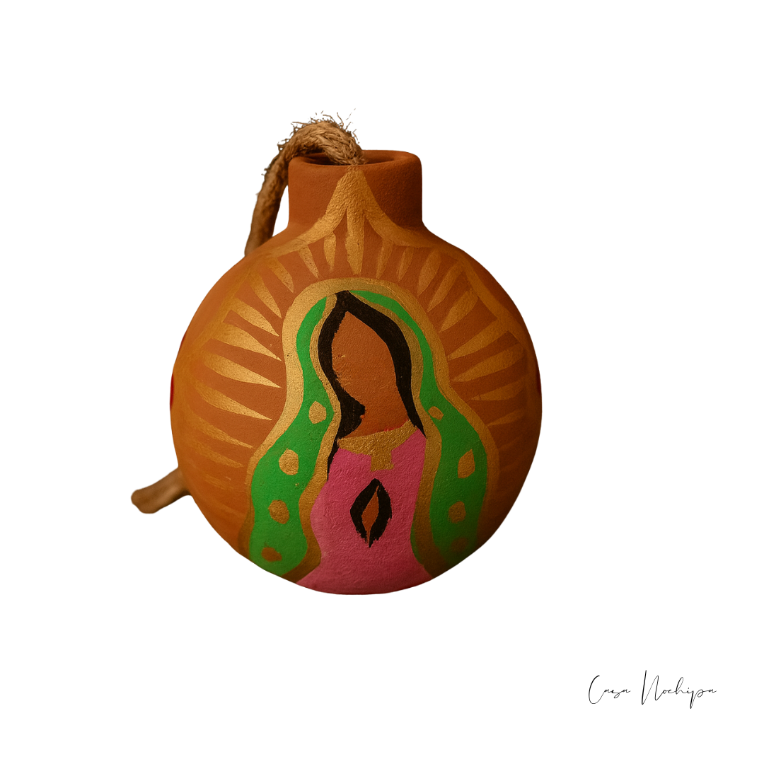 Esfera de barro pintada a mano con imagen de la Virgen de Guadalupe sobre fondo negro.