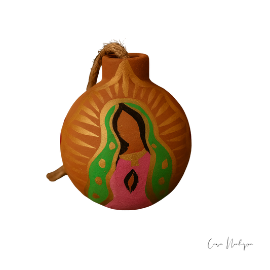 Esfera de barro pintada a mano con imagen de la Virgen de Guadalupe sobre fondo negro.