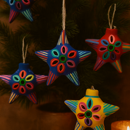 Estrella navideña de barro pintada a mano en azul con diseño floral multicolor.
