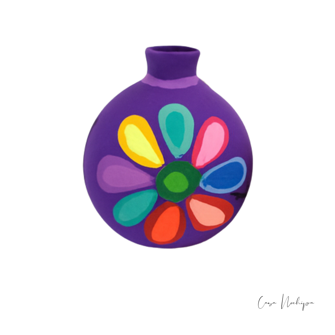 Esfera navideña morada de barro con diseño floral pintado a mano en colores vivos.